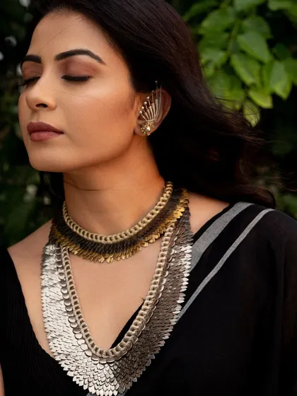 A portrait that focuses on the beautiful, cascading necklace. The closed eyes draw attention to the jewelry and create a serene mood.