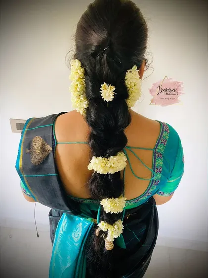 A simple and elegant traditional braid adorned with jasmine flowers. This is a classic and graceful hairstyle for any cultural event.