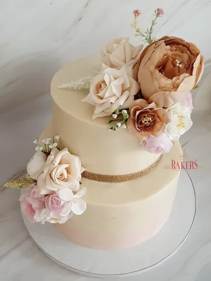 A beautiful no-fondant cake in a nude color palette for an engagement party. The subtle ombre effect and the arrangement of rustic, neutral-toned flowers give it a sophisticated and modern feel.