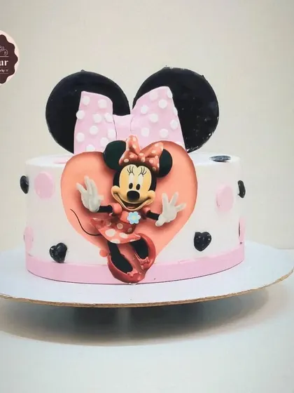 A sweet Minnie Mouse cake with her iconic bow and ears as the topper. The heart-shaped frame and polka dot details make this a lovely choice for a fan of the classic character.