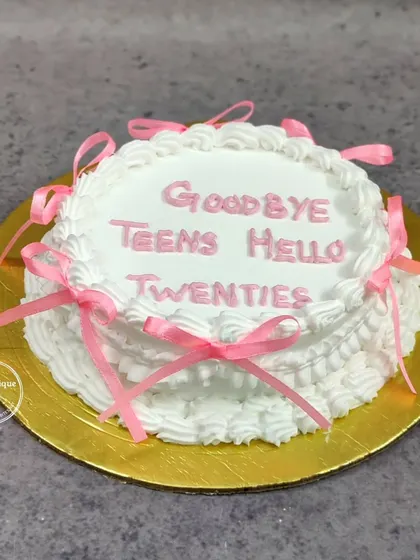 A fun vintage-style cake celebrating the transition from the teens to the twenties, with "Goodbye Teens Hello Twenties" piped on top.