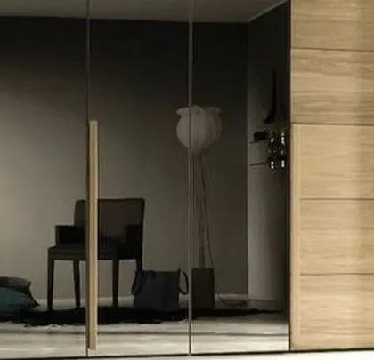 A stylish wardrobe combining smoked mirror and wood panel doors for a chic and sophisticated appearance.