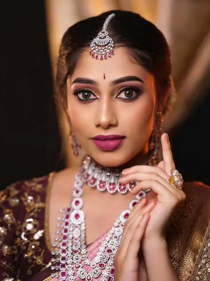 A playful and engaging portrait. The makeup is glamorous and photo-ready, perfect for capturing all the special moments of the day.