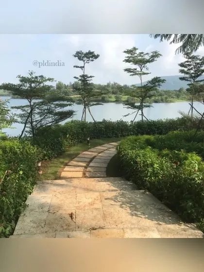 From the top of a set of stone stairs, the pathway unfolds, inviting a walk down towards the lake. The elevated perspective shows how the path is carefully integrated into the natural topography of the site.
