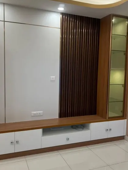 A custom TV unit with a mix of closed storage, a glass display cabinet, and a fluted wood panel. This design is both highly functional and aesthetically pleasing.