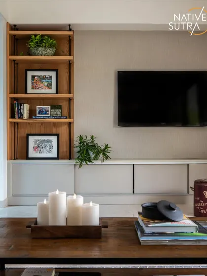 This TV console area exemplifies modern minimalism with Scandinavian warmth. The open wooden shelving provides space for personal photos and books, while the clean lines of the console maintain an uncluttered and tranquil feel.