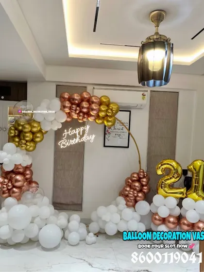 Celebrating a 21st birthday with a touch of class. This elegant ring backdrop is decorated with a cascade of rose gold, gold, and white balloons, complete with a "Happy Birthday" neon sign for a modern look.