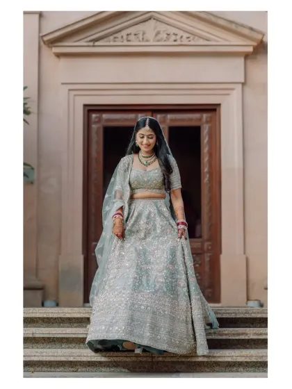 A beautiful full-length portrait of the bride walking down the steps of a grand building.