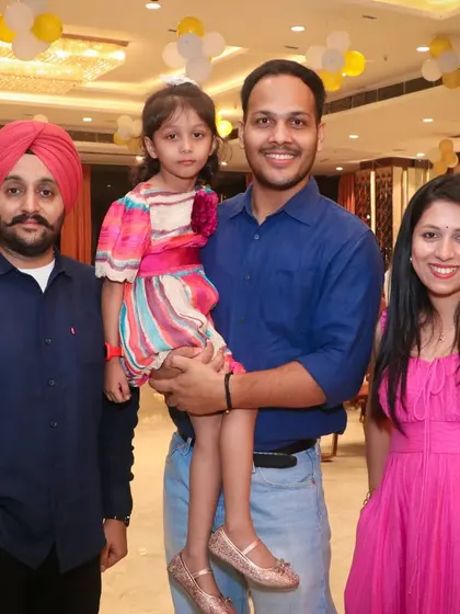 A group of friends and family, including a young child, pose for a photo. Our photographers are great at interacting with guests to get natural smiles.