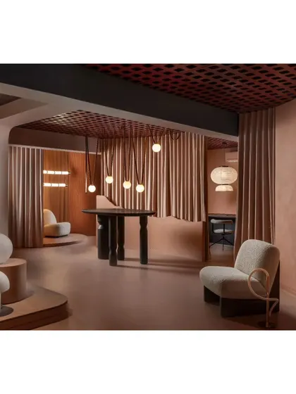 An overall view of the showroom's dynamic layout. The combination of open spaces and intimate nooks, all unified by the peach color scheme and grid ceiling, creates a cohesive yet varied retail experience.