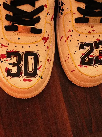 A basketball-inspired design with a twist. I painted these Nike Air Force 1s with a red and blue paint splatter effect, custom jersey numbers on the toe box, and a swoosh that looks like a basketball.