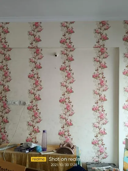 A bedroom wall with a vertical floral stripe wallpaper, a classic design that adds height and elegance.