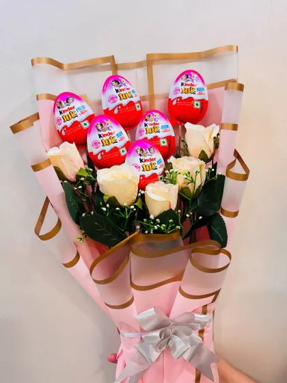 For the child who loves surprises, I designed this beautiful bouquet combining elegant white roses with a handful of Kinder Joy eggs. It's a unique twist on a classic gift.