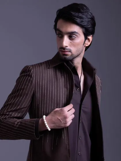 Elegance redefined. This brown pinstripe suit celebrates culture and style with a modern twist, perfect for the man who appreciates a classic pattern.