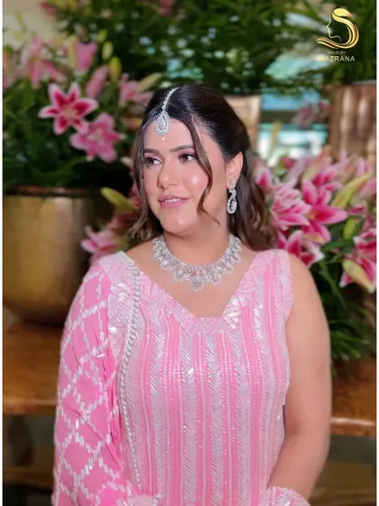 A portrait of the client looking radiant in her Manish Malhotra outfit and pearl-accented hairstyle.