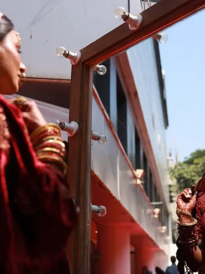 The bride getting her final touches, seen in a mirror. A great behind-the-scenes shot that captures the preparation.