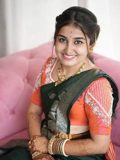 A close-up of the bride, showing the intricate beading on the sleeves of her peach-colored blouse.