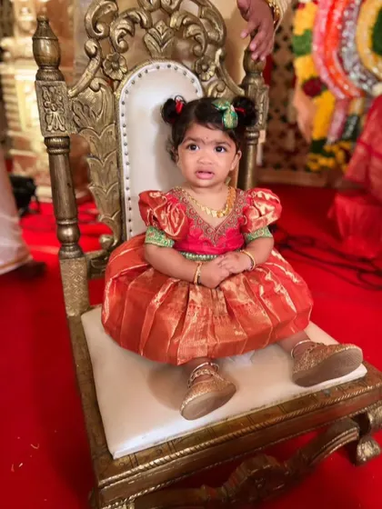Seated like royalty on her little throne, this cutie is wearing her custom silk frock for a special ceremony.
