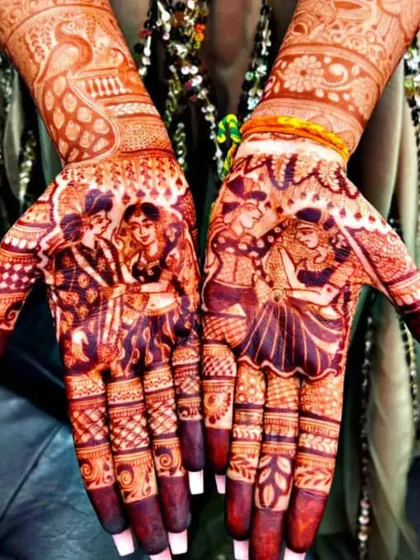The rich, dark stain of a portrait mehendi. This shows how the fine details of the couple's figures remain sharp and clear after the henna paste is removed.