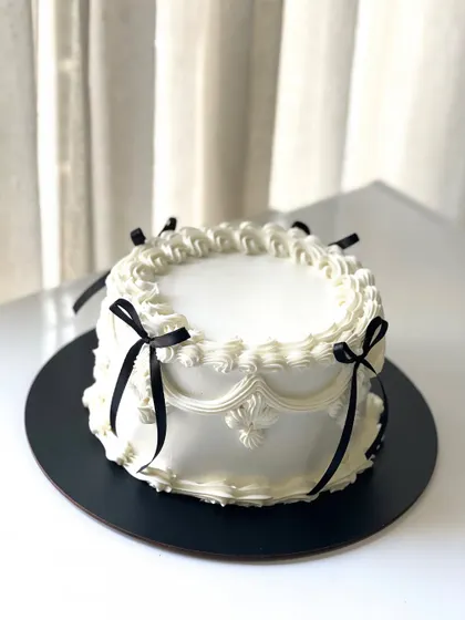 Vintage vibes and buttercream dreams. This is my take on the classic Lambeth cake trend, featuring intricate piping and elegant black ribbons.