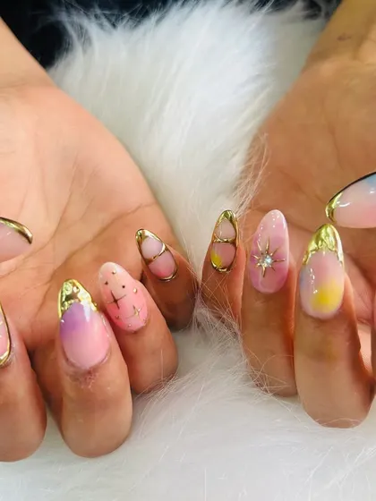 A fun and colorful set perfect for a party or vacation. These nails feature a pastel rainbow ombré, gold chrome accents, and sparkling starburst details for a truly festive look.
