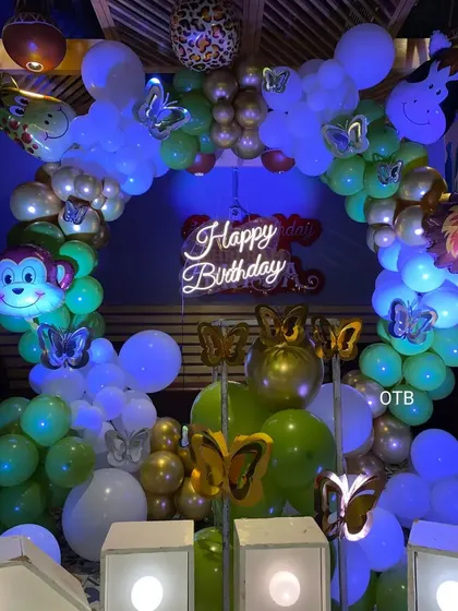 A jungle and butterfly theme for Harshita's first birthday. This unique combination uses green and gold balloons with butterfly accents for a magical forest feel.