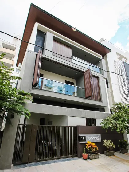 An angled perspective of the 'Ananthaksha' residence, showing the depth and layering of the facade with its balconies and movable screens.