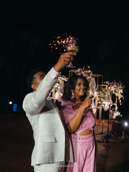 The newly engaged couple raises a toast, with fireworks in the background.