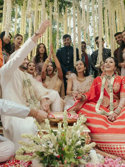 The couple shares a laugh with their friends and family during the wedding rituals. These candid group moments are precious memories.