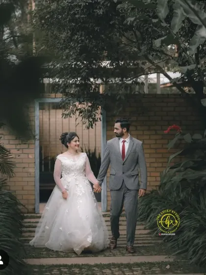 A walking shot through a garden path, showcasing the couple's coordinated formal wear. This is a perfect example of a classic, elegant look for a post-wedding album.