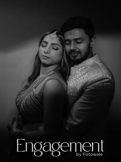 A powerful black and white engagement portrait. The couple's serene expressions and close embrace create a dramatic and intimate image that speaks of deep connection.