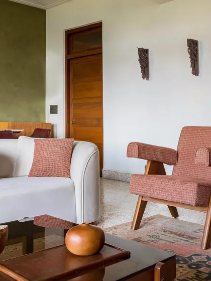 The living room of Apartment 5026, a revival of a 1950s Art Deco home. We honored the apartment's original character by using vintage-style furniture and a reclaimed terrazzo floor, while introducing contemporary details for a fresh, modern feel.