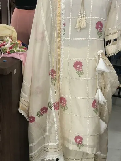 A close-up of the custom suit, highlighting the beautiful block print, lace detailing, and handcrafted tassels on the kurta.