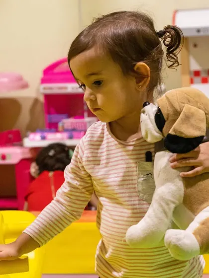 Cuddles with a soft toy puppy in our play area. It's a cozy and comforting space for little ones.