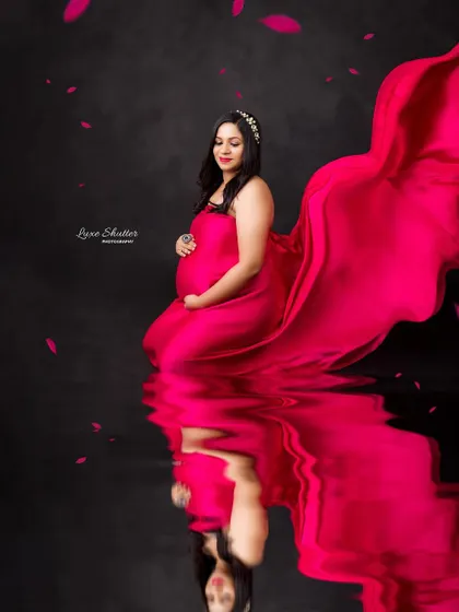 A creative edit with a water reflection, doubling the impact of the flowing red fabric. This adds an artistic and dreamy quality to the maternity photo.