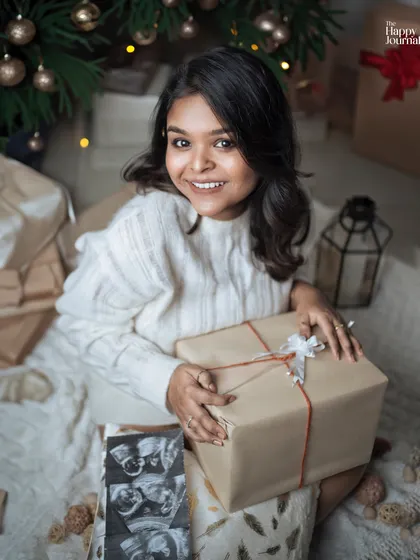 A festive holiday-themed maternity shoot! Surrounded by presents and a Christmas tree, this mom-to-be is celebrating the greatest gift of all.