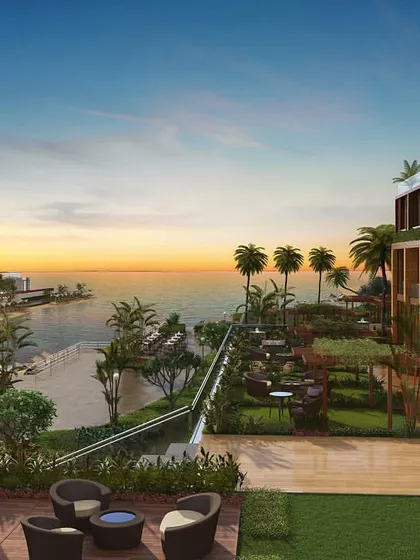 A sunset view from a high vantage point within the coastal development, looking out over the property towards the ocean and marina.
