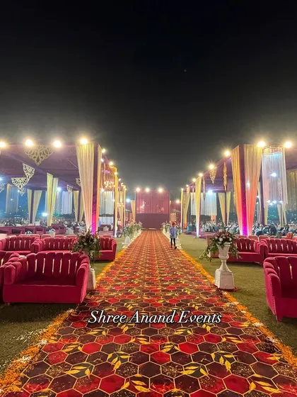 A long, patterned carpet runner flanked by plush pink sofas creates a luxurious and comfortable pathway for guests.