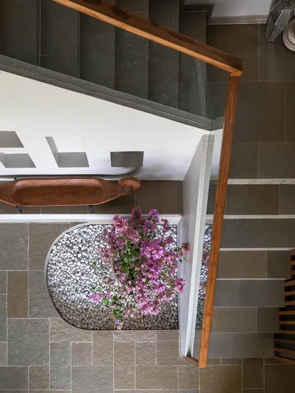 An overhead view of the entryway at Grove House, showing the stone flooring and a small indoor garden beneath the stairs.