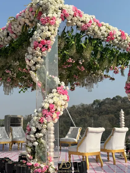 A detailed view of the spiral floral arrangement on a modern mandap pillar, showcasing the intricate work of weaving pink and white roses together.