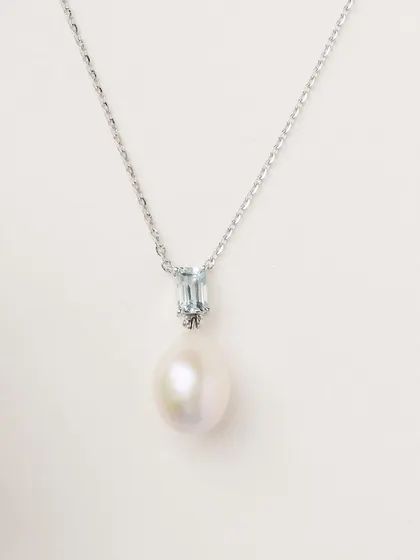 A close-up of the Blue Topaz and Pearl pendant necklace. The combination of the cool blue topaz and lustrous South Sea pearl is effortlessly elegant.
