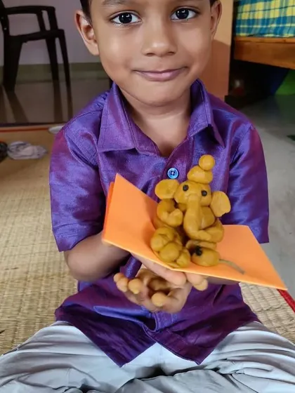 This boy's happy expression shows his pride in the turmeric Ganesha he crafted. These hands-on festival preparations are among the most memorable learning experiences.