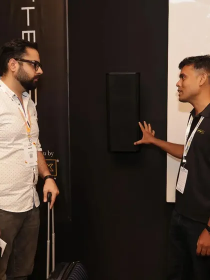 Our team explaining the benefits of our on-wall speaker solutions to an interested visitor at our expo booth.