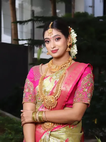 A full portrait of the South Indian bride. Her entire look, from the makeup and hair to the saree and jewelry, comes together to create a picture of elegance.