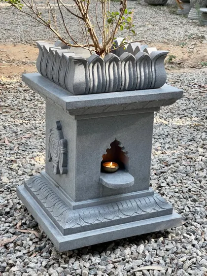 Our large black granite Tulasi Brindavan, shown with a lit diya in its niche, is an ideal platform for the auspicious Tulasi plant.