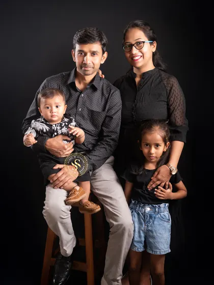 A family of four, including a baby, posed comfortably in our studio. We are patient and experienced in working with young children to capture beautiful moments.
