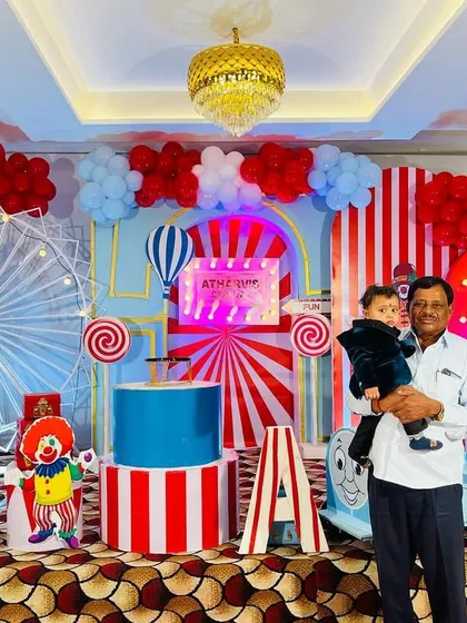 A guest enjoying the grand carnival setup, showcasing the scale and detail of the stage decor.