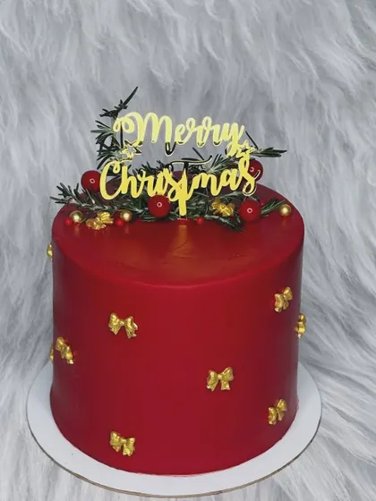 The festive season continues with this elegant red Christmas cake. Adorned with delicate golden bows and a "Merry Christmas" topper, it's simple, classic, and delicious.