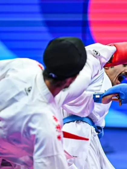A close-up action shot from an international bout. This demonstrates the intensity of high-level Kumite, where split-second decisions determine the winner.