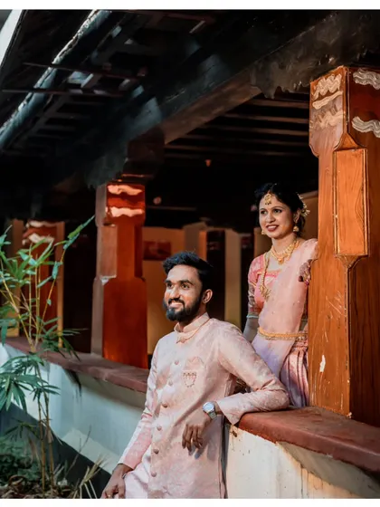 A lovely portrait of a couple during their engagement ceremony, captured in the beautiful, traditional architecture of a heritage building.